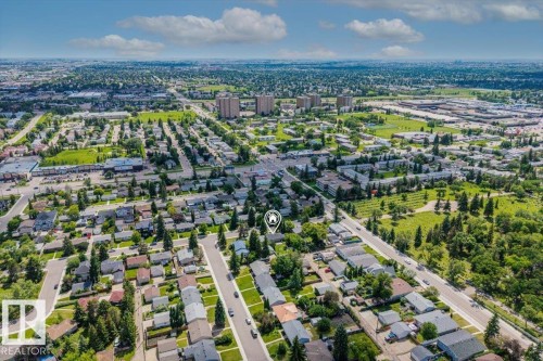 Residential neighborhood showcasing a grid street pattern and individual homes, surrounded by abundant mature trees and green spaces - 10544 53 Avenue, Edmonton, AB 
