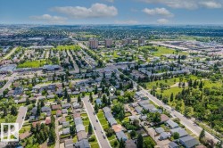 Residential neighborhood showcasing a grid street pattern and individual homes, surrounded by abundant mature trees and green spaces - 