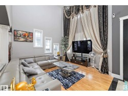 Living area featuring double-height ceilings and hardwood flooring - 