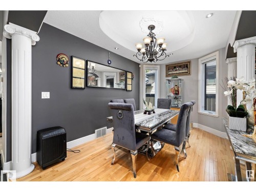 Dining space featuring hardwood flooring, decorative ceiling medallion, and a chandelier - 9544 154 Street, Edmonton, AB 
