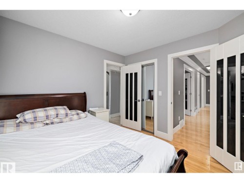 Bedroom featuring light gray walls, wood-finish flooring, and white trim - 9544 154 Street, Edmonton, AB 