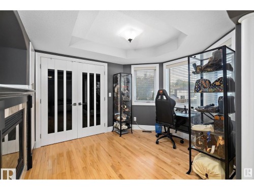Bright space featuring wood-finish flooring, a tray ceiling, and dual paned windows with blinds - 9544 154 Street, Edmonton, AB 