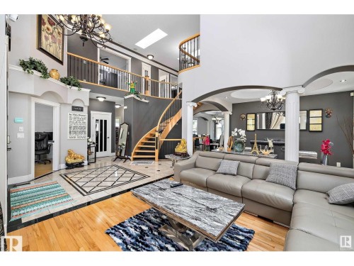Grand foyer with a curved staircase, hardwood flooring, and decorative tile inlay - 9544 154 Street, Edmonton, AB 