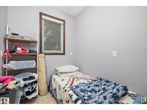 Compact room with light gray walls, a single window featuring wood-finish trim and horizontal blinds, and ceramic tile flooring - 9544 154 Street, Edmonton, AB 