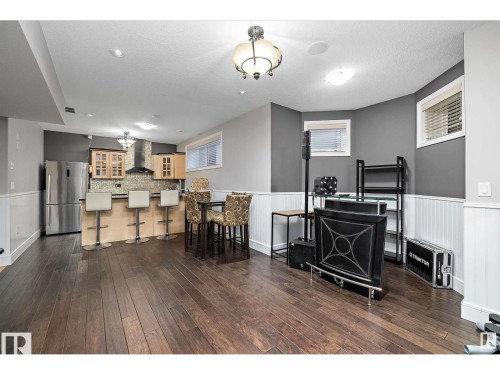 Open-concept space featuring dark wood-finish flooring, white wainscoting, and recessed lighting - 9544 154 Street, Edmonton, AB 