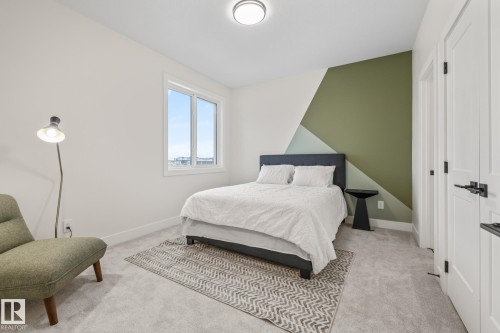 Carpeted room featuring a window, painted accent wall, and white trim - 132 Edgewater Circle, Leduc, AB 
