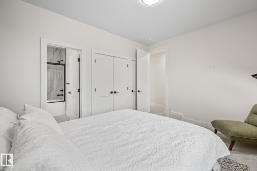 Bedroom featuring light grey carpeting, white walls, and a ceiling-mounted light fixture - 132 Edgewater Circle, Leduc, AB 