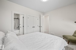 Bedroom featuring light grey carpeting, white walls, and a ceiling-mounted light fixture - 