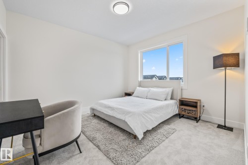 Bright room featuring a large window, plush carpet, and a modern ceiling light fixture - 132 Edgewater Circle, Leduc, AB 