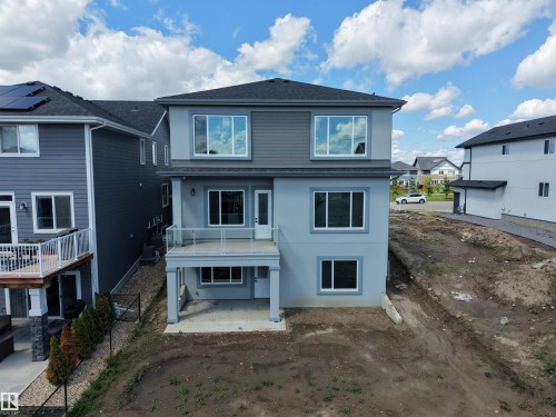Contemporary two-story residence with a multi-textured facade featuring light gray stucco and darker gray siding - 132 Edgewater Circle, Leduc, AB 