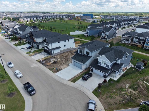 Modern residential development featuring a variety of architectural styles, including two-story homes with dark roofs and light-colored siding - 132 Edgewater Circle, Leduc, AB 