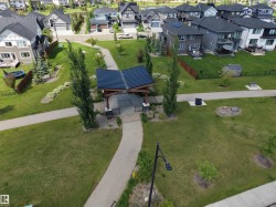Community green space featuring a covered pavilion with dark metal roofing and wood-look support beams - 