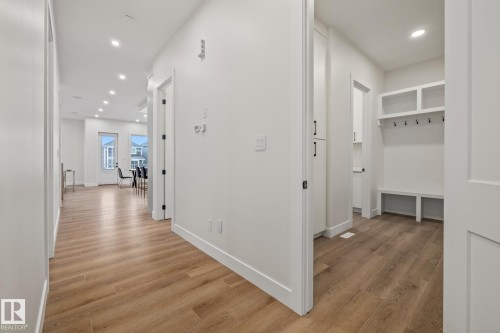 Entryway featuring wood-finish flooring, recessed lighting, and a built-in mudroom bench with storage cubbies and coat hooks - 132 Edgewater Circle, Leduc, AB 
