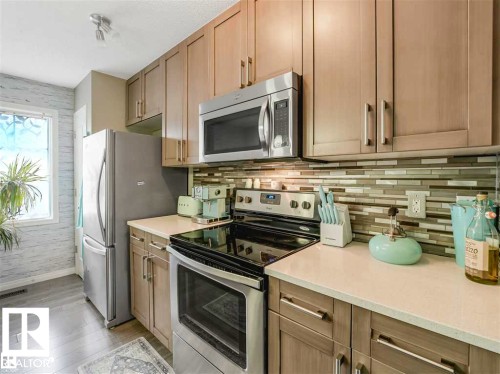Kitchen featuring wood-finish cabinetry and light-toned countertops - 44 1140 Chappelle Boulevard, Edmonton, AB 