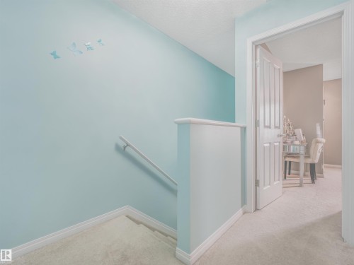 Carpeted staircase with white handrail and pale blue walls - 44 1140 Chappelle Boulevard, Edmonton, AB 