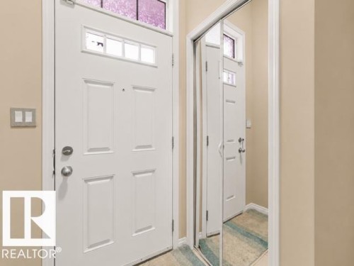 White paneled entry door with transom window and multi-pane window insert - 44 1140 Chappelle Boulevard, Edmonton, AB 