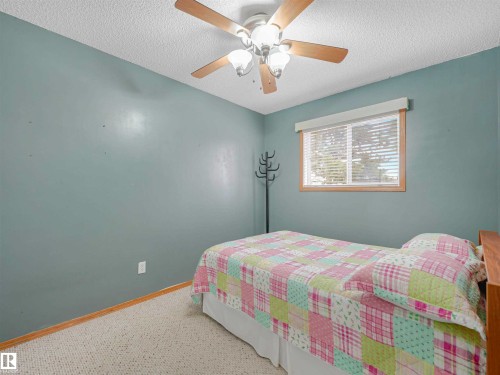 Room featuring a ceiling fan with light kit, window with horizontal blinds, and wood-trim baseboards - 13825 128A Avenue, Edmonton, AB - Indoor Photo Showing Bedroom