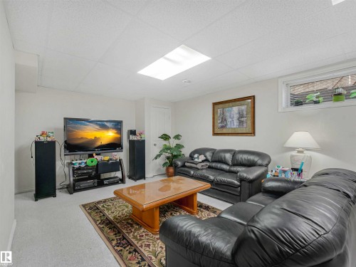 Living area with a skylight, window with blinds, and white painted walls - 13825 128A Avenue, Edmonton, AB - Indoor Photo Showing Living Room