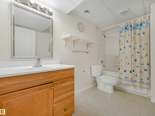 Light wood-finish vanity with a white countertop and integrated sink - 13825 128A Avenue, Edmonton, AB - Indoor Photo Showing Bathroom