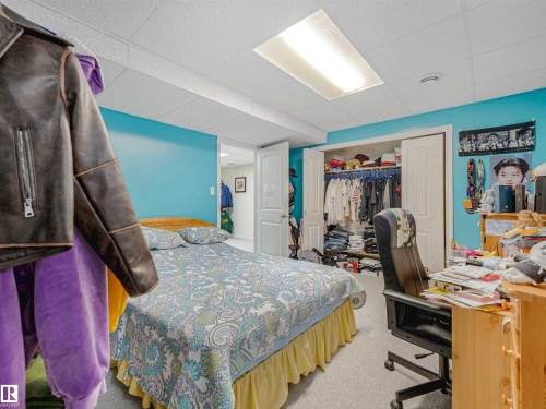 Carpeted room featuring a ceiling-mounted fluorescent light fixture and white bi-fold closet doors - 13825 128A Avenue, Edmonton, AB - Indoor