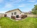 Expansive rear yard featuring a multi-level wooden deck with railing, perimeter fencing, and raised garden beds - 13825 128A Avenue, Edmonton, AB  - Outdoor 