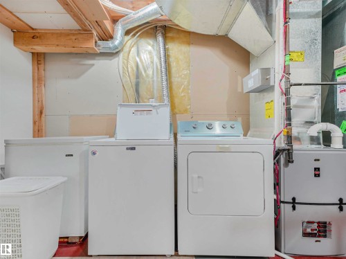 Utility area featuring a washer, dryer, furnace, and exposed ceiling joists - 13825 128A Avenue, Edmonton, AB - Indoor Photo Showing Laundry Room