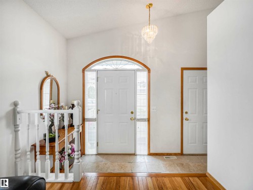Entryway featuring vaulted ceilings, a decorative chandelier, and a wood-trimmed archway framing the main door - 13825 128A Avenue, Edmonton, AB - Indoor Photo Showing Other Room