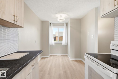 Light wood-finish flooring extending throughout, complemented by light-toned wall paint - 186 Cornell Crest, Edmonton, AB 