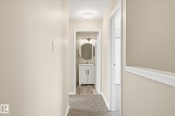 Hallway featuring neutral wall tones, carpet flooring, and a flush mount ceiling light - 