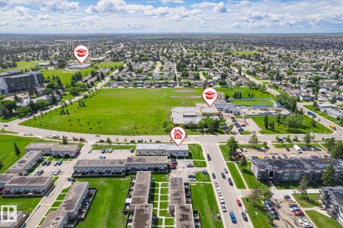 Aerial view showcasing a residential neighborhood with extensive green spaces and multiple buildings - 186 Cornell Crest, Edmonton, AB 