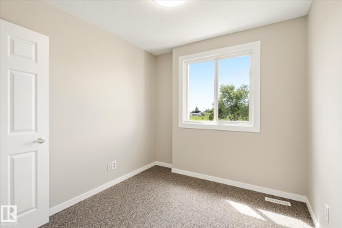 Neutral tone wall paint, white trim, and a window offering exterior views - 186 Cornell Crest, Edmonton, AB 