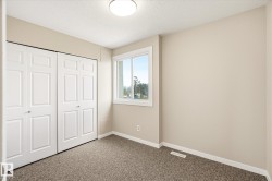 Bedroom featuring neutral-toned walls, white trim, and a window with white casing - 