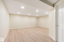 Spacious room featuring wood-finish flooring, recessed lighting, neutral wall tones, and white trim - 