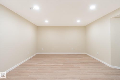 Spacious room featuring wood-finish flooring, recessed lighting, and neutral wall tones - 186 Cornell Crest, Edmonton, AB 