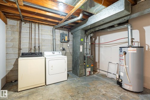 Utility area featuring exposed joist ceiling, concrete block walls, a water heater, a furnace, and exposed ductwork - 186 Cornell Crest, Edmonton, AB 