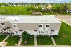 Multi-unit residential property featuring flat roofs and a neutral-toned exterior - 