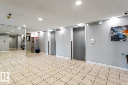 Building lobby featuring twin elevators. - #602 12303 Jasper Av Nw, Edmonton, AB - Indoor Photo Showing Other Room