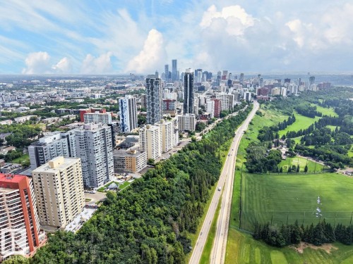 Urban corridor location showcasing proximity to downtown skyline, mature tree-lined green spaces, and established residential neighbourhoods - #602 12303 Jasper Av Nw, Edmonton, AB - Outdoor With View
