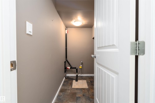 Utility room with durable tile-patterned flooring, neutral wall paint, and overhead flush-mount lighting - 12246 103 Street, Edmonton, AB - Indoor Photo Showing Other Room