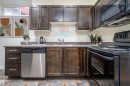 Kitchen featuring wood-finish cabinetry, stone-look countertops, and a tile backsplash - 12246 103 Street, Edmonton, AB  - Indoor Photo Showing Kitchen 