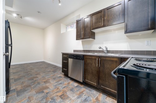 Kitchenette featuring dark wood cabinetry, stainless steel dishwasher, black electric range, and a double basin sink - 12246 103 Street, Edmonton, AB - Indoor Photo Showing Kitchen