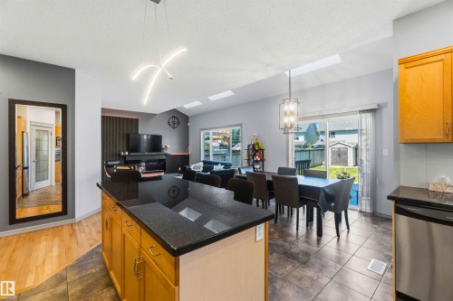 Kitchen island with a dark countertop and wood-finish cabinetry - 3061 Spence Wynd, Edmonton, AB 