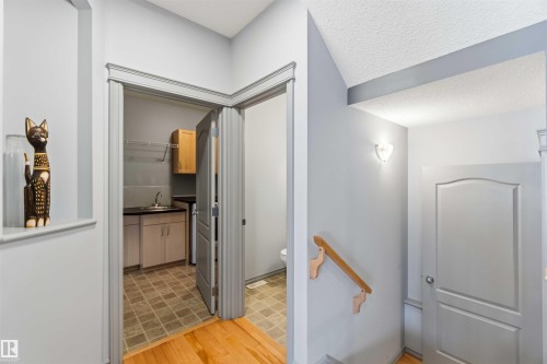 Utility room featuring a stainless steel sink, wood-finish cabinetry, and tiled flooring - 3061 Spence Wynd, Edmonton, AB 