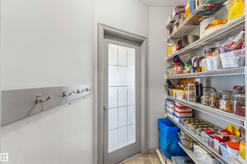 Wire shelving system, glazed panel door, light-toned wall paint, and coat hooks - 3061 Spence Wynd, Edmonton, AB 
