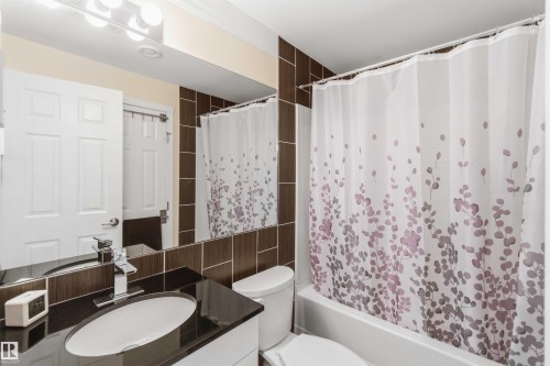 Bathroom featuring a vanity with an undermount sink, a dark countertop, and a chrome faucet - 3061 Spence Wynd, Edmonton, AB 