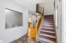 Foyer featuring a carpeted staircase with wood banister and wrought iron spindles - 3061 Spence Wynd, Edmonton, AB 