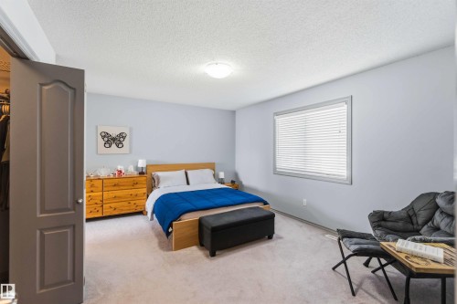 Light-filled bedroom featuring soft gray walls and light-toned carpeting - 3061 Spence Wynd, Edmonton, AB 