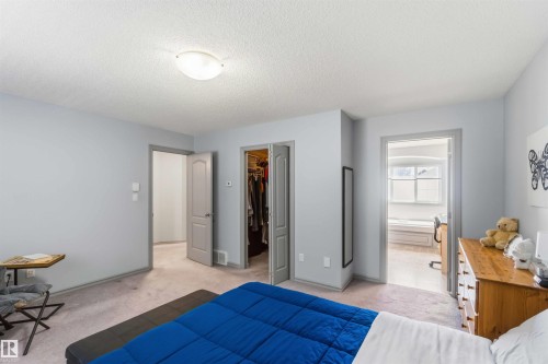 Spacious room featuring light gray walls, textured ceiling, and light-colored carpet flooring - 3061 Spence Wynd, Edmonton, AB 