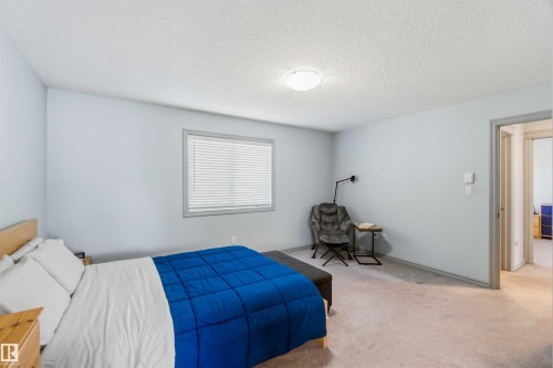 Spacious room featuring light grey walls, a single window with horizontal blinds, and neutral-toned carpeting - 3061 Spence Wynd, Edmonton, AB 