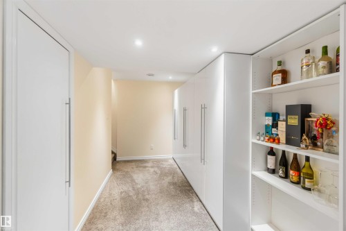 Hallway featuring recessed lighting, light-toned carpeting, and built-in white cabinetry with full-length pulls - 3061 Spence Wynd, Edmonton, AB 